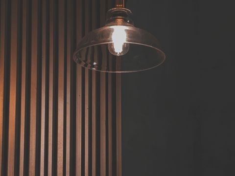 Drvene zidne letvice i viseća lampa u polumraku